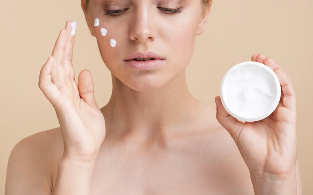 Primer plano de una mujer aplicandose crema para la piel en el rostro. Dermalife
